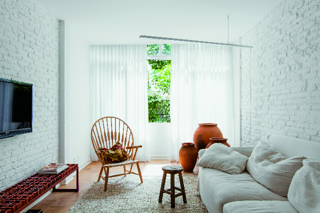 Neste apartamento de 98 m2, o arquiteto Alan Chu apostou em texturas nas paredes, entre tijolinhos à vista e cobogós. A parede da sala foi descascada para expor os tijolos, acrescentando textura ao ambiente