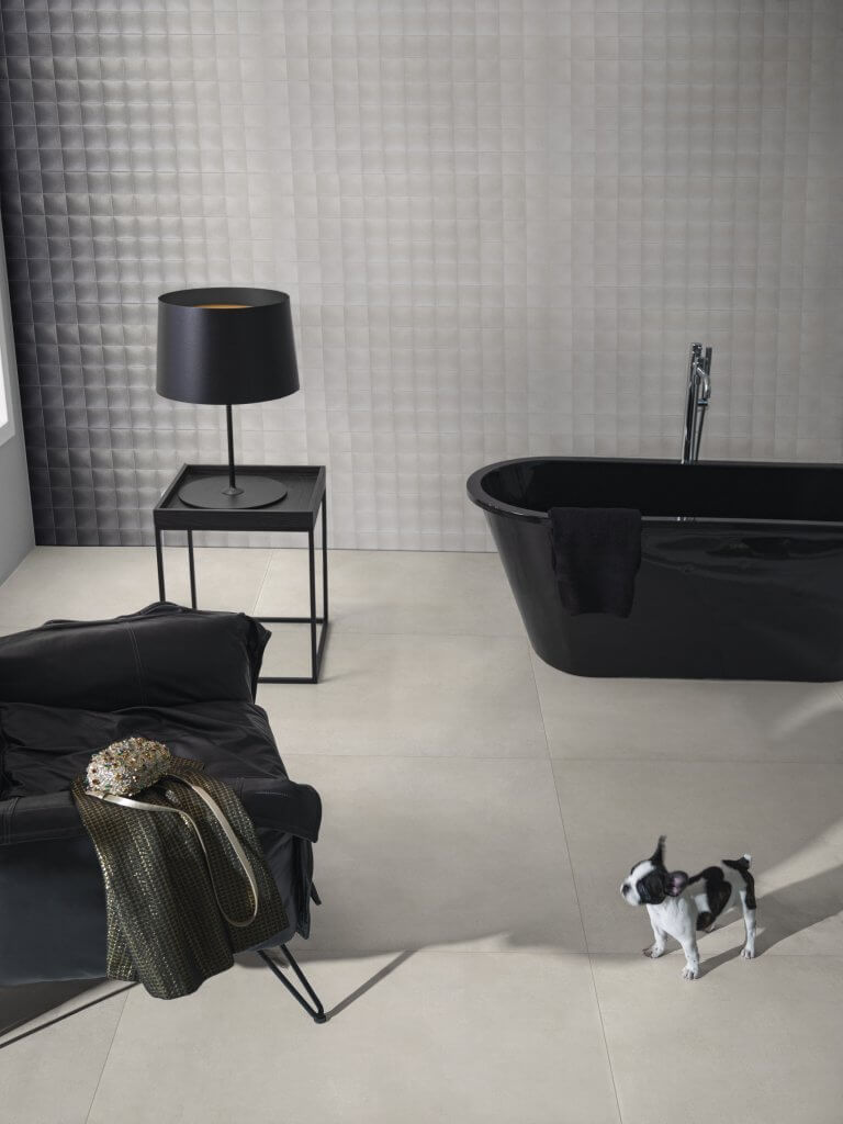 tendências de decoração no banheiro com banheira, cadeira e abajur pretos e com piso Zeppelin Gray e Vitória Gris Ombre e Vitória Gris na parede 