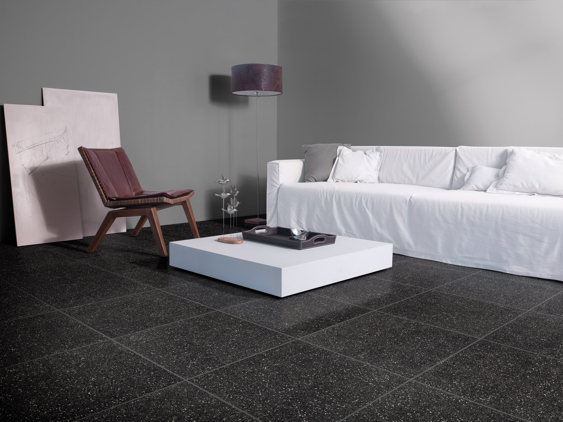 Bellini Nero, no piso, promove contraste com o sofá neutro branco, compondo um ambiente com visual urbano