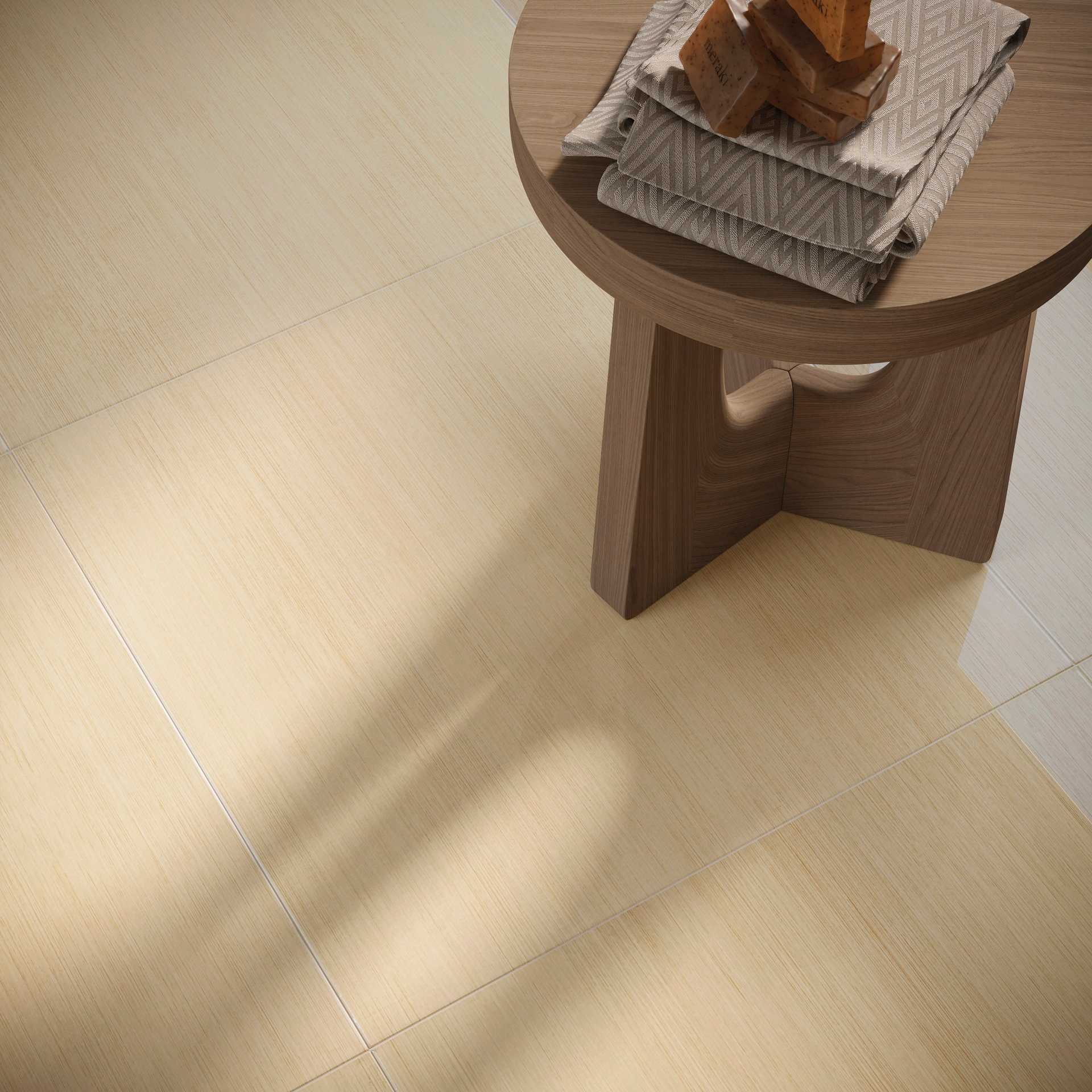 detalhe de piso amadeirado com mesa também de madeira e livros sobre o tampo