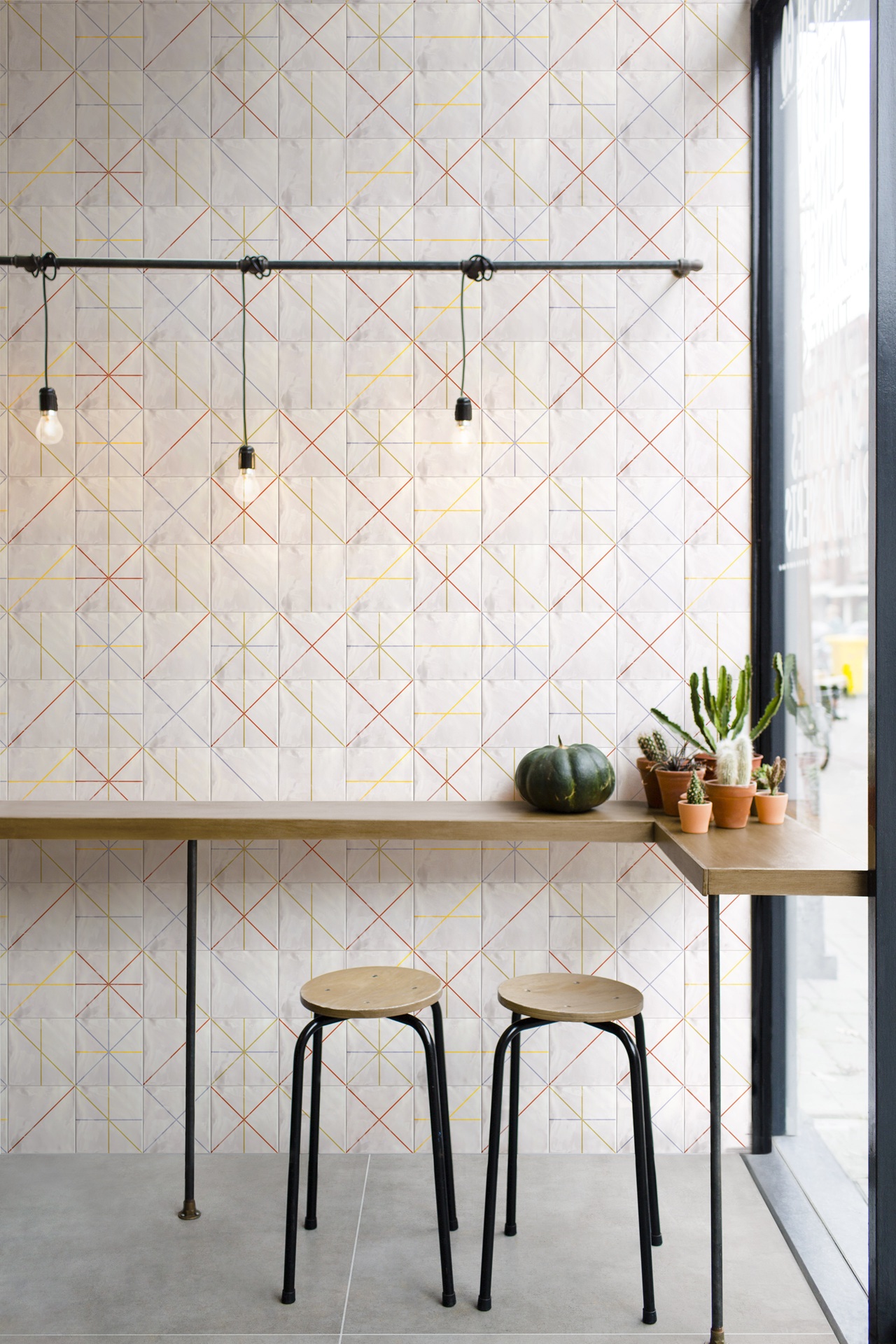 bancada de cozinha com mobiliario de maeira e parede com cerâmica geométrica